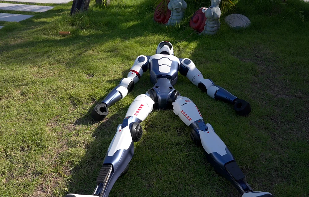 Dwa roboty Unitree R1 Basic leżą na plecach – demonstracja możliwości ruchowych i testów scenariuszy.