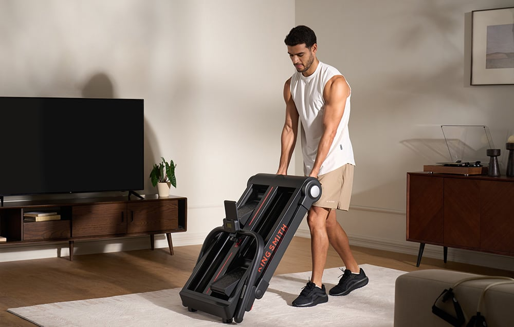 Mężczyzna składający stepper KINGSMITH Stair Go STE001 w salonie