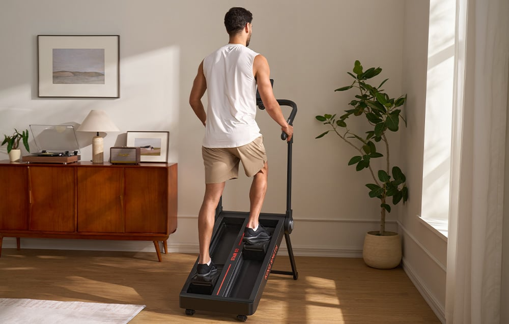 Mężczyzna ćwiczący na stepperze KINGSMITH Stair Go STE001 z aplikacją treningową