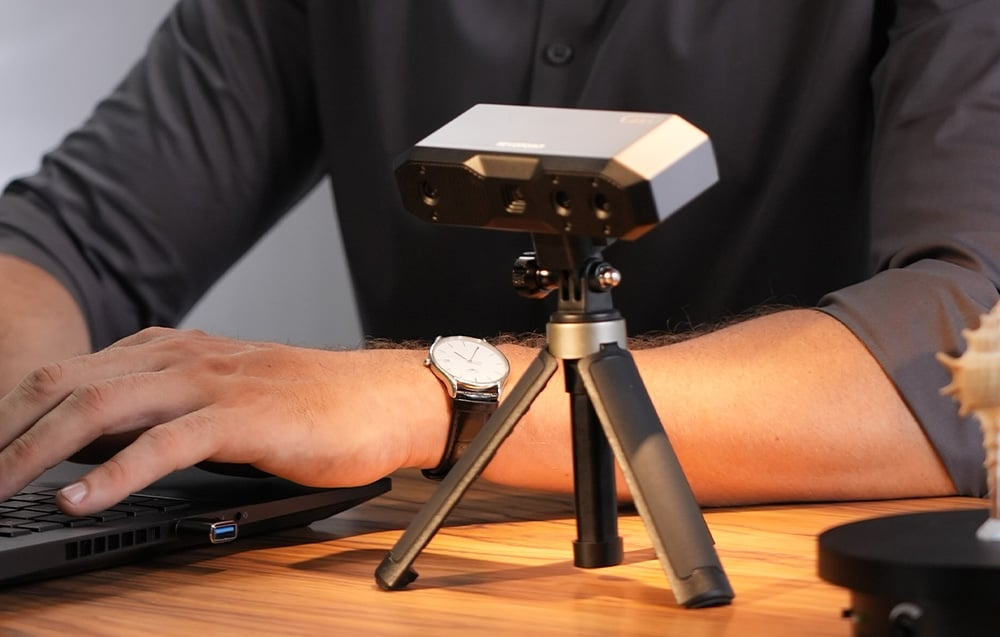 Skaner Revopoint MINI 2 na statywie podczas pracy przy laptopie
