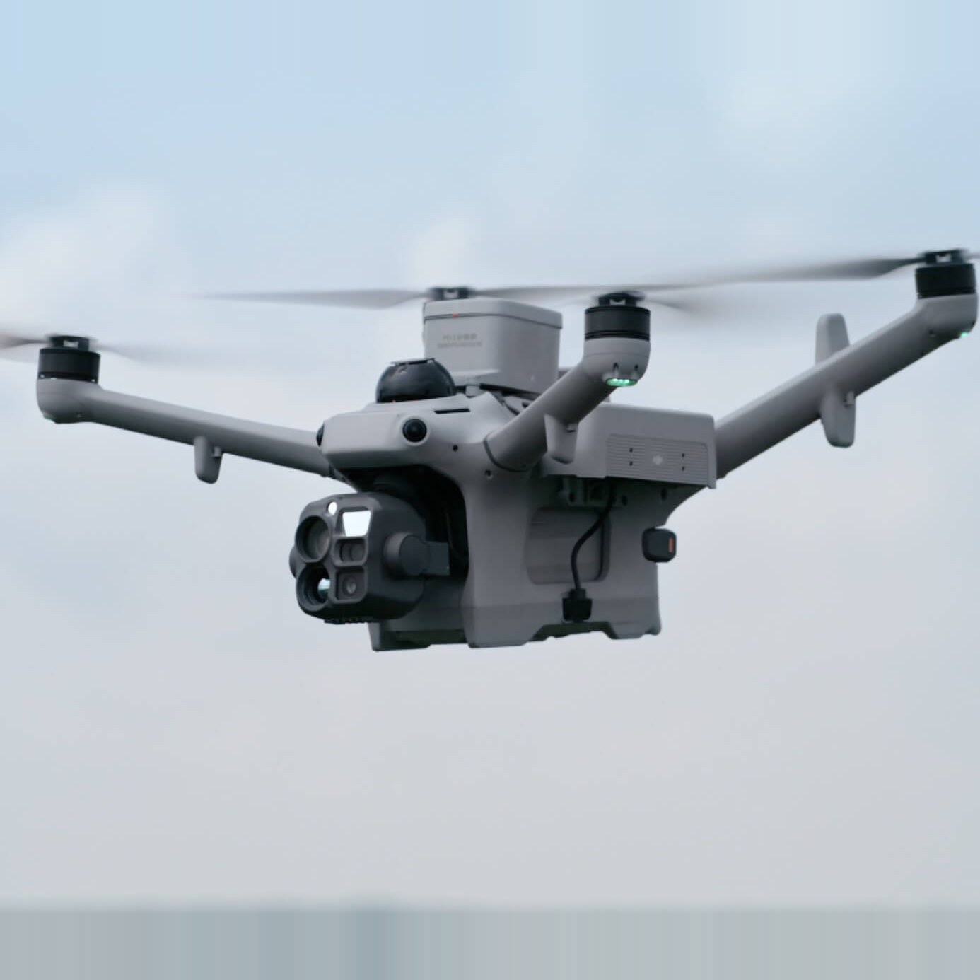 Dron DJI Matrice 5TD w locie z głowicą kamer skierowaną do przodu