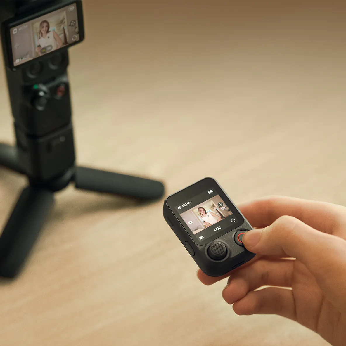 Osmo FrameTap w dłoni obok kamery Osmo Pocket 4P na statywie